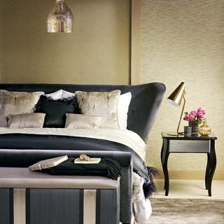 gold bedroom with black bed