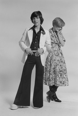 English singer David Van Day, of pop group Guys 'n' Dolls, and a young woman, modelling fashionable outfits, 24th March 1975.