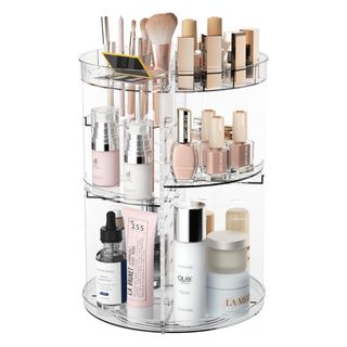 A clear acrylic makeup organizer filled with products