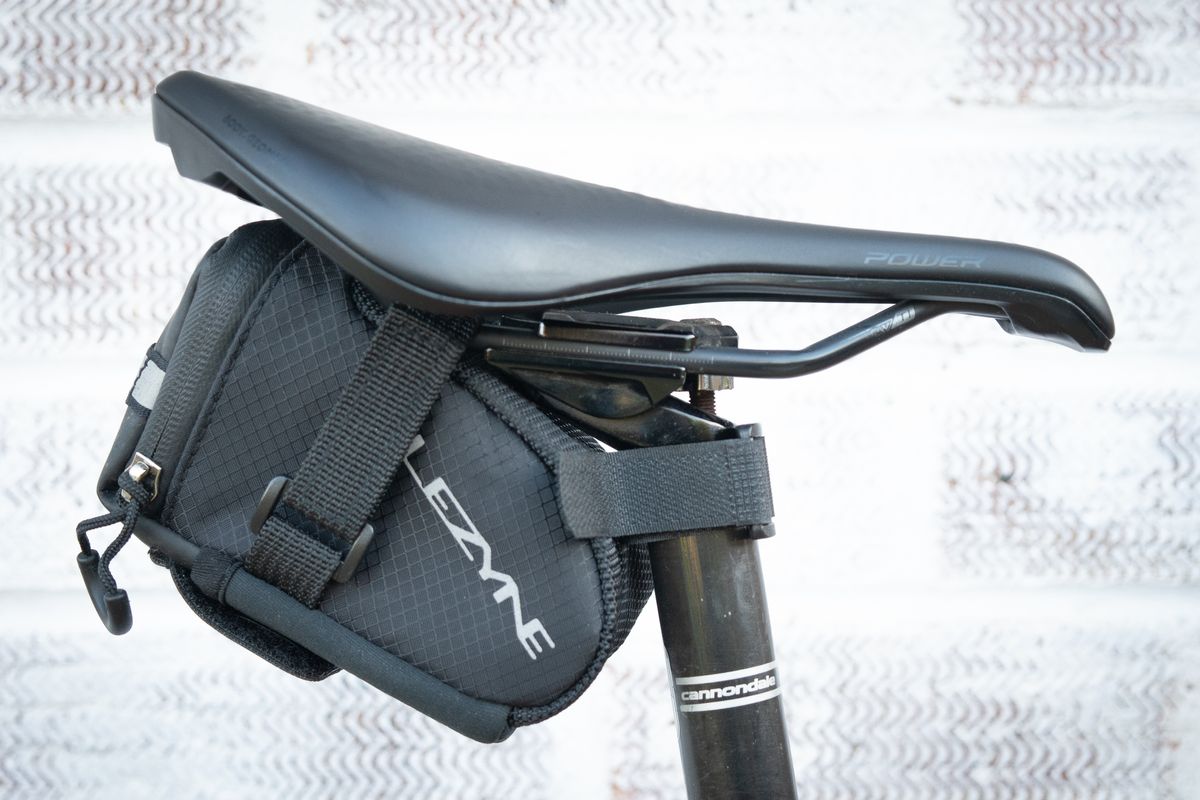 Black Lezyne saddle bag attached to saddle rails and seatpost using velcro
