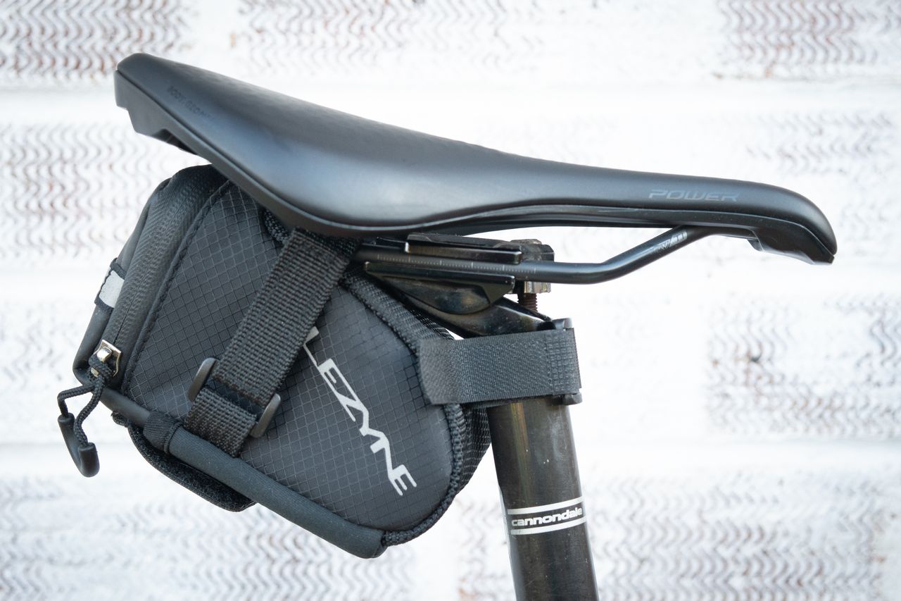 Black Lezyne saddle bag attached to saddle rails and seatpost using velcro