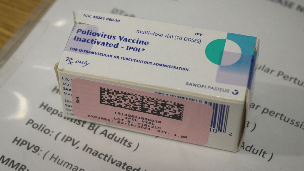 photo of a white box labeled &quot;poliovirus vaccine - inactivated;&quot; box is sitting on top of a white piece of paper with a list of common vaccines printed on it, including ipv, the inactivated polio vaccine