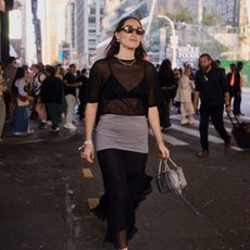 a street style image of Anna LaPlaca during NYFW wearing a sheer St. Agni top with a Tory Burch Skirt