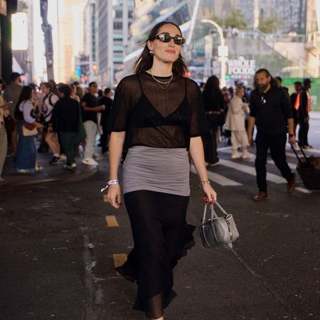 a street style image of Anna LaPlaca during NYFW wearing a sheer St. Agni top with a Tory Burch Skirt