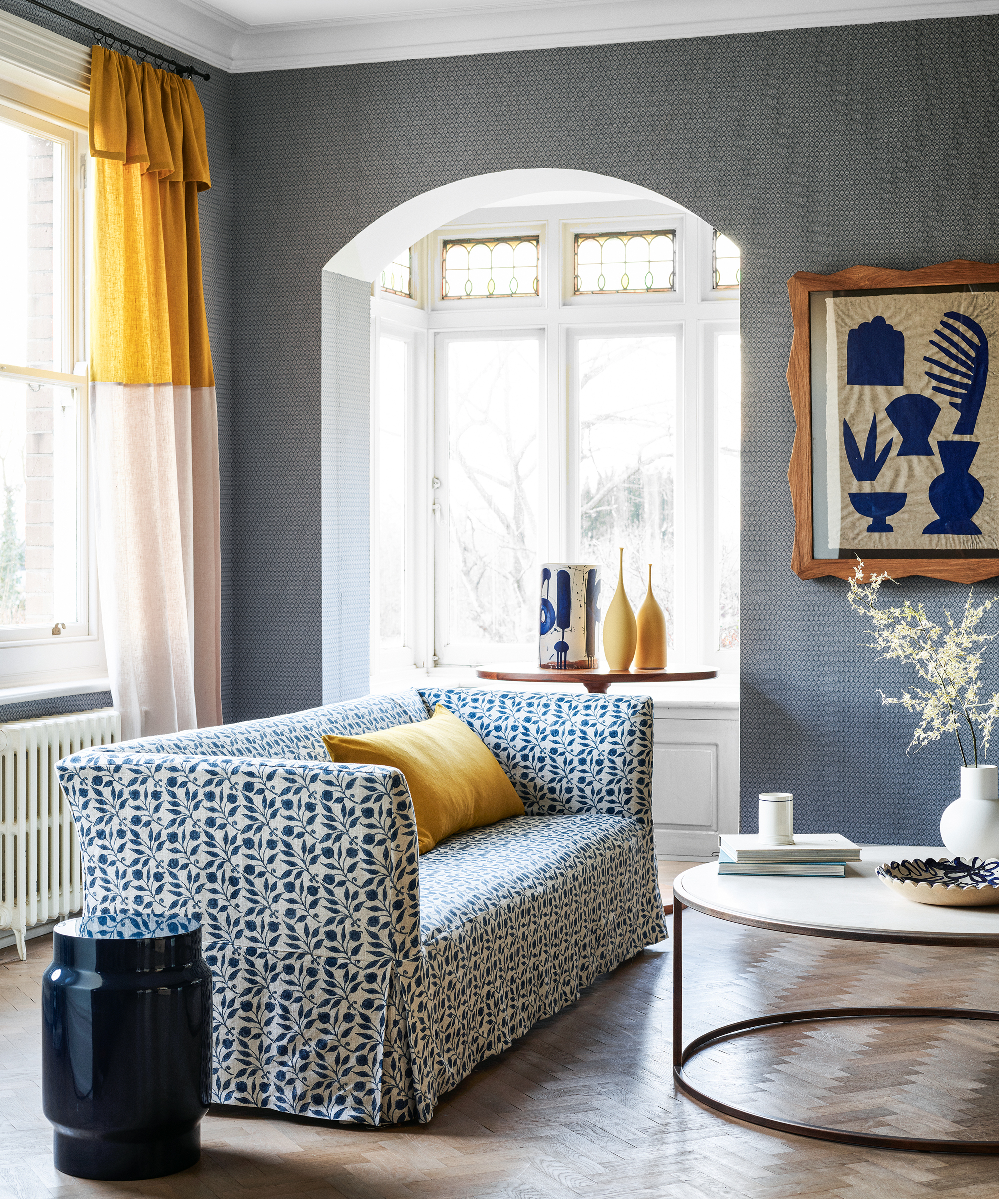 A living room with blue wallpaper and yellow accents