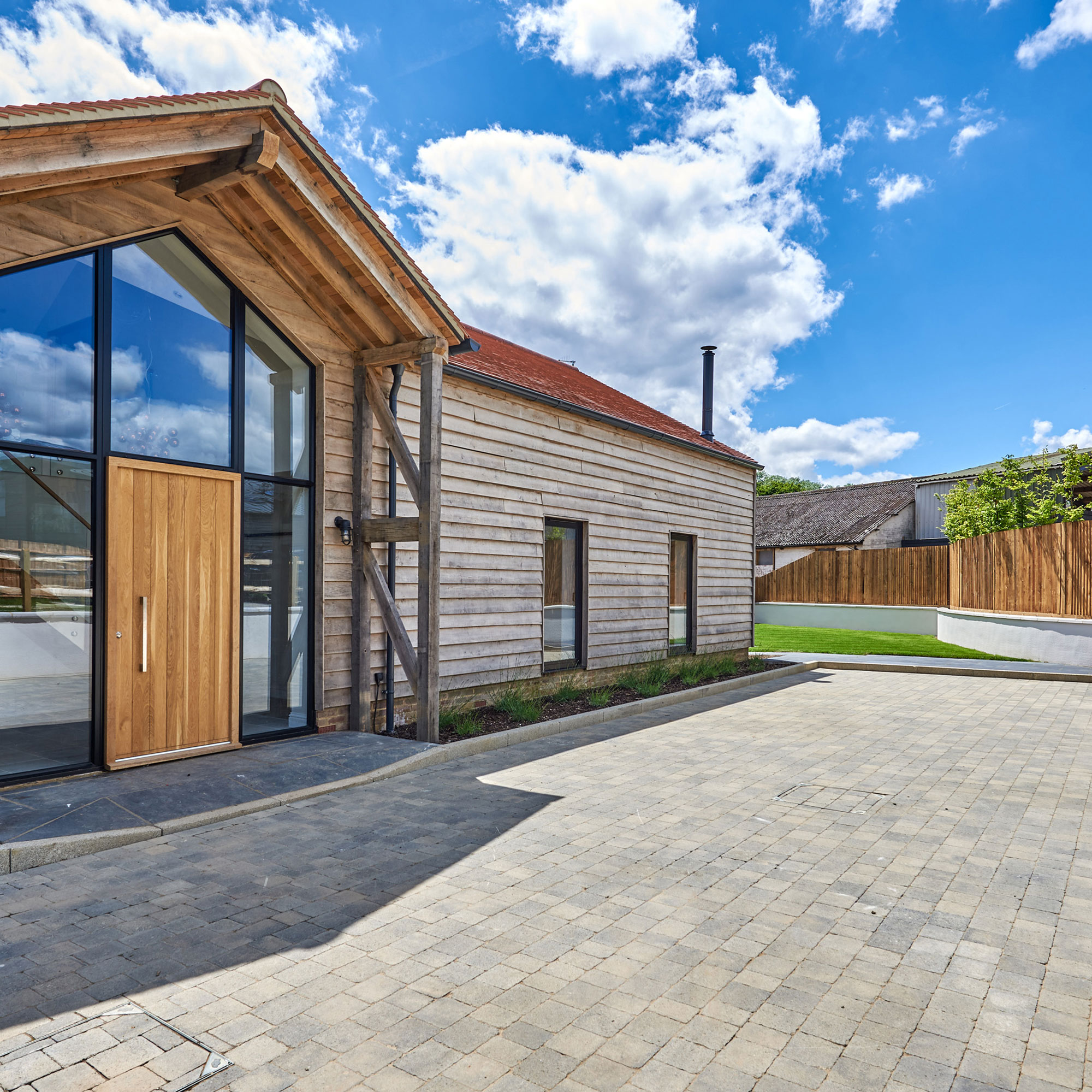 modern timber clad house with block paved driveway
