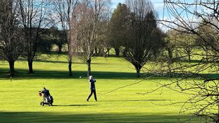 Female golfer hitting a fairway wood