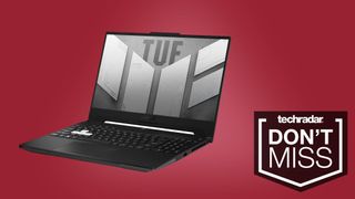 a black laptop open and displaying the TUF logo against a pink