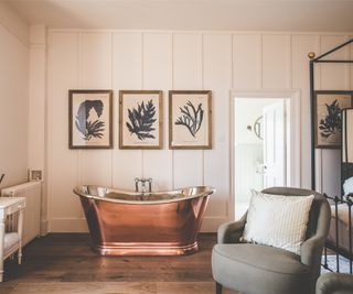 copper bath on painted wood panelled wall in between bedroom and bathroom