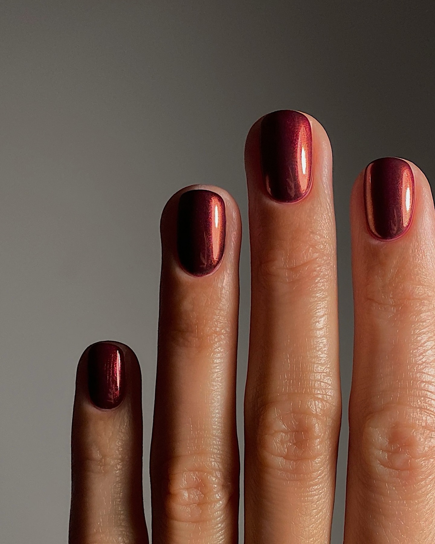 Short dark red nails with chrome powder