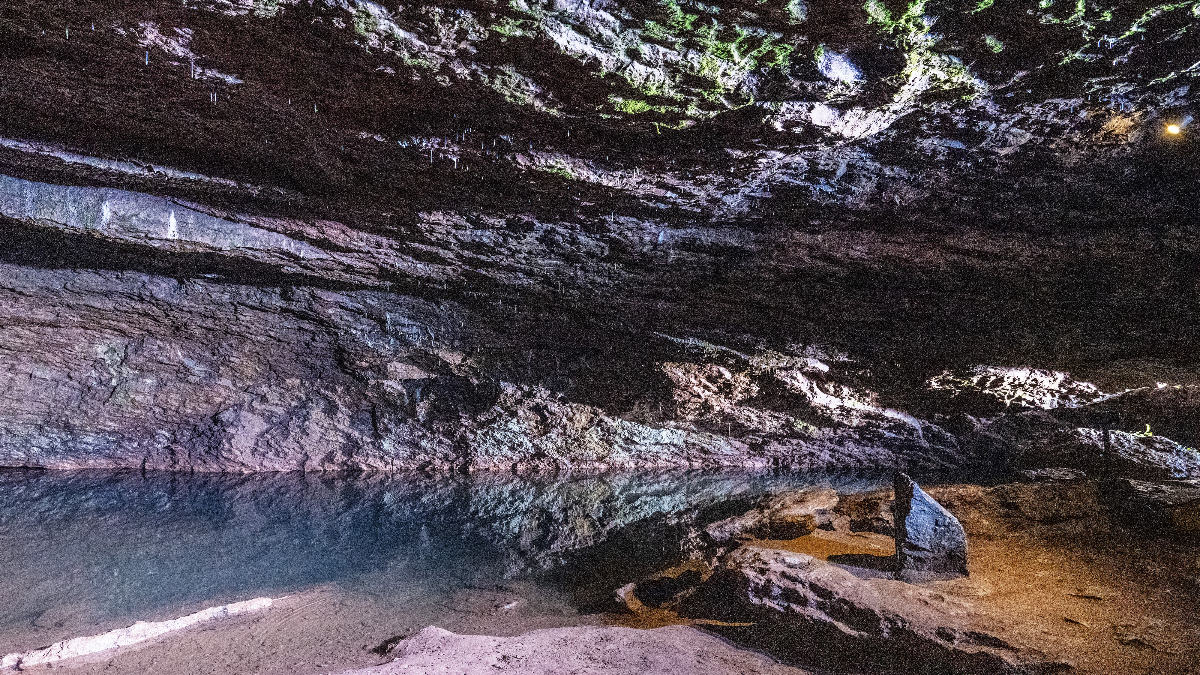 Pool of water in a cave with reflections of the cave wa