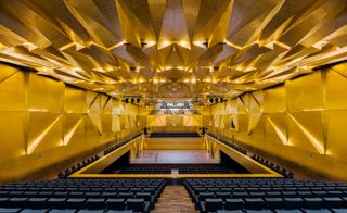 Auditorium with yellow walls & ceiling design