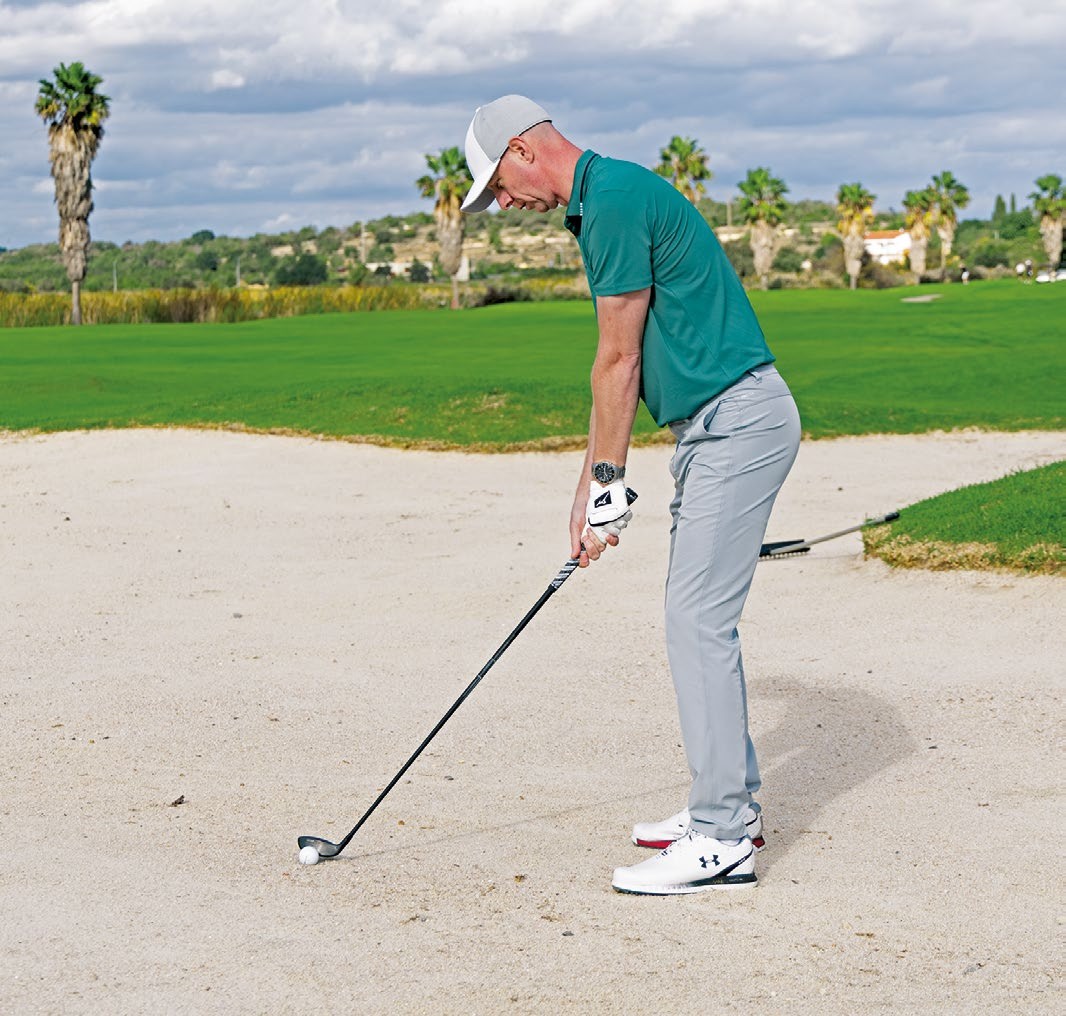 Ged Walters assessing the lie before determining whether to hit hybrid out of the fairway bunker