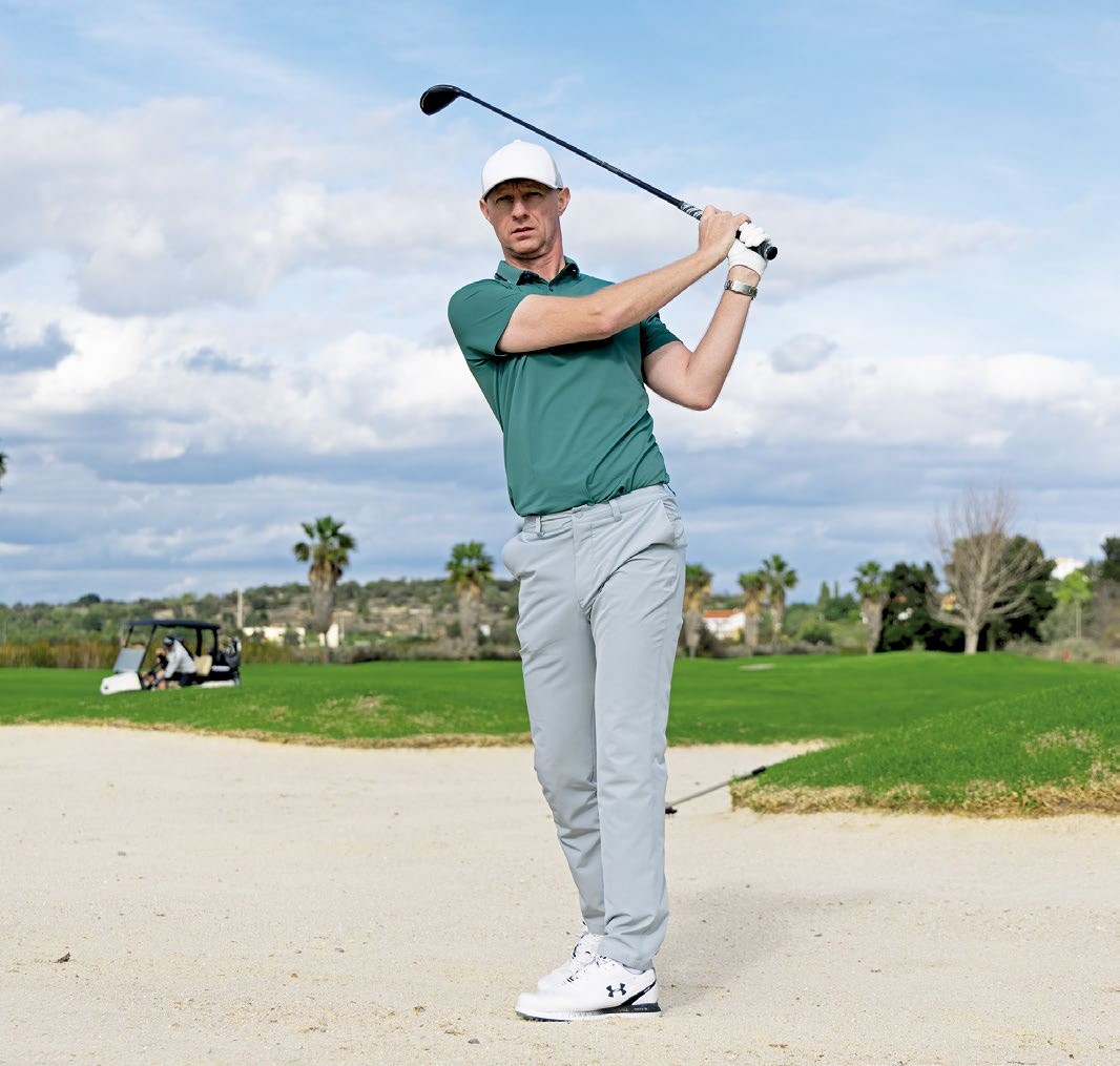 Ged Walters in the finish position with a hybrid and weight on lead side after hitting a hybrid out of the fairway bunker