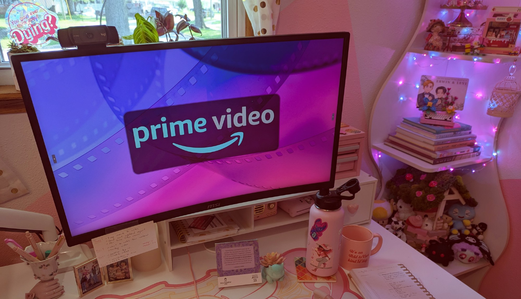 A Prime Video logo on a desktop screen in a pink and white office