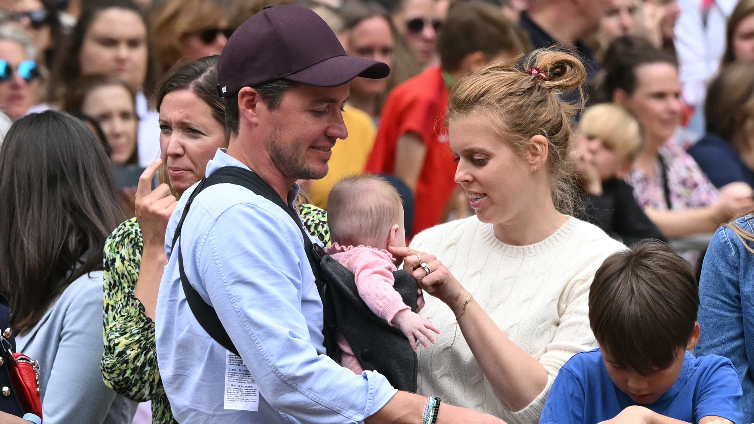 Princess Beatrice of York strokes her daughter Athena's cheek as she and Edoardo Mapelli Mozzi line the Mall waiting to greet the bus carrying the England women's national football team