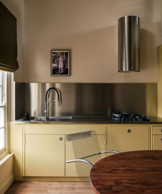 yellow art deco inspired kitchen walls and cabinets with stainless steel countertops and accessories