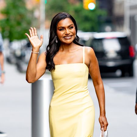 Mindy Kaling wearing a yellow dress and Christian Louboutin clear heels 