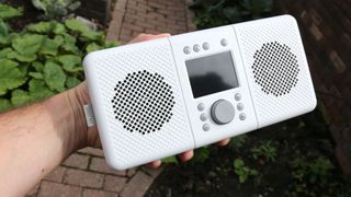 a hand holding the pure elan connect+ dab radio