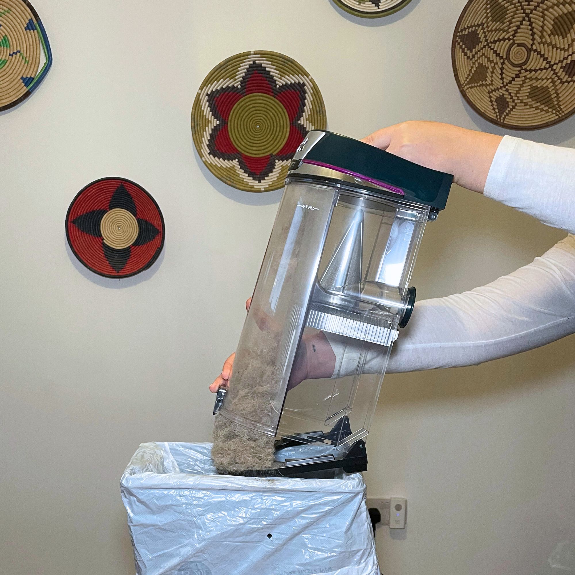 Emptying the dust bin of the Shark PowerDetect Powered Lift-Away Upright Pet Vacuum Cleaner AZ3900UKT over a kitchen bin