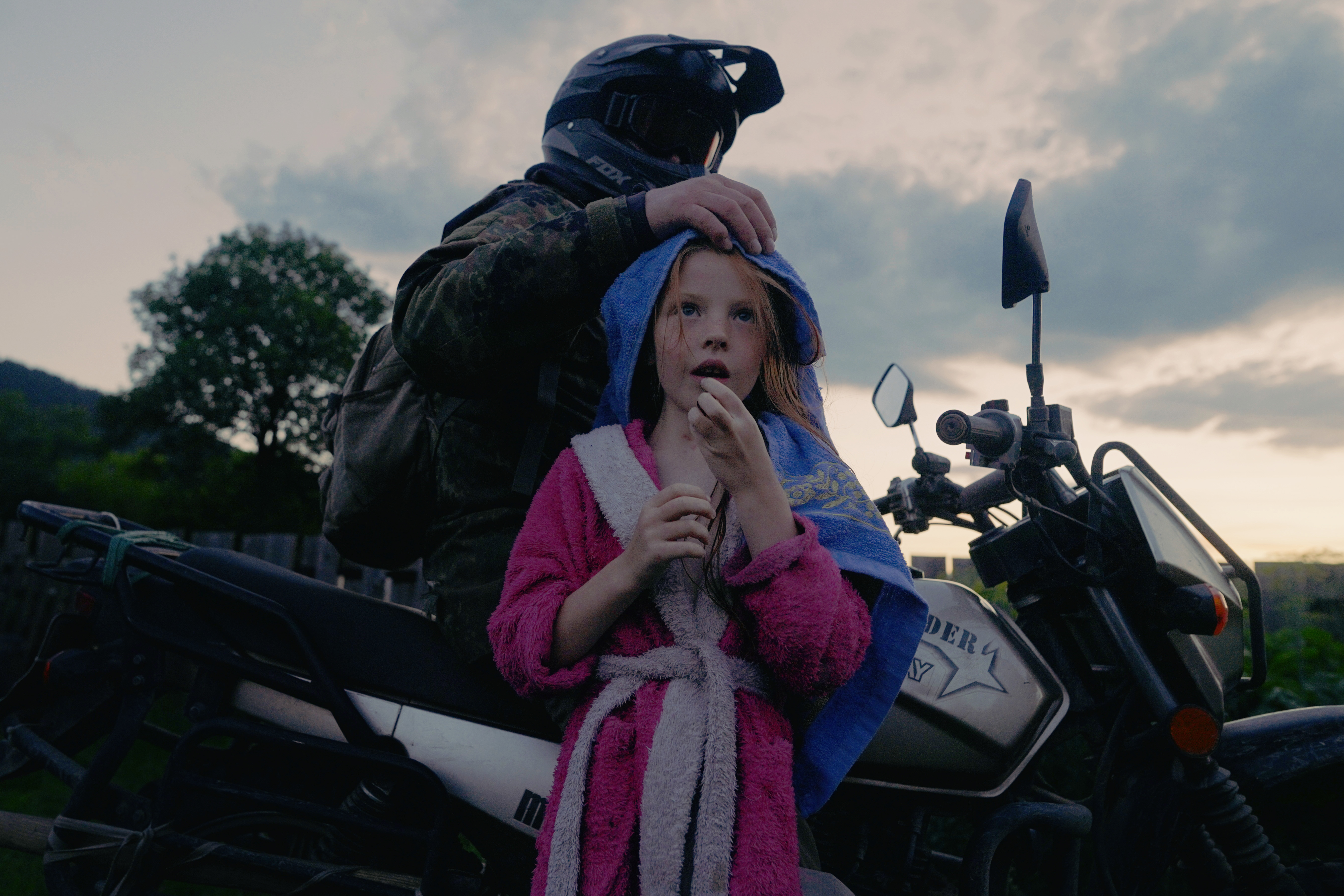 Man on motorcycle with his hand on daughters head by Alina Prisich