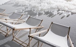 White astroturf beach, white deck chairs and translucent plastic balls for sea foam