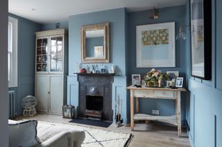 blue living room with original fireplace and artwork on walls