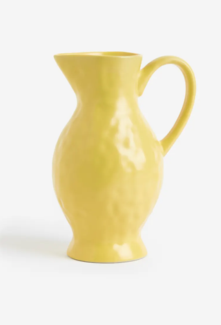 yellow stoneware pitcher on a white background