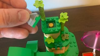 A hand placing a brick piece onto Lego Kapp'n's Island Boat Tour