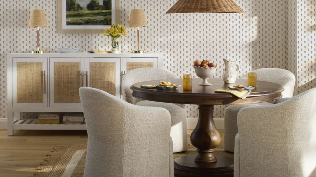wayfair dining room with rattan scalloped rug and boucle style dining chairs, round wooden table and white sideboard