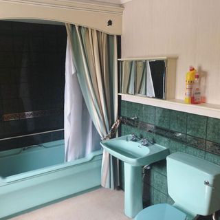 bathroom with green marble tiles wall mint green bathtub and wash basin
