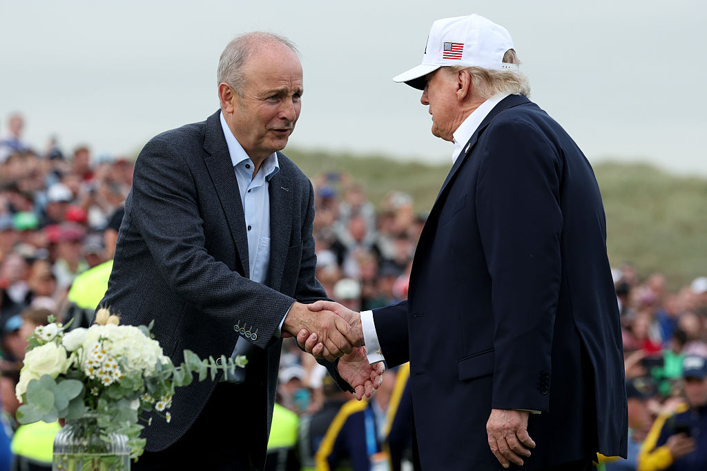 President Donald Trump (R) shakes hands with Irish Taoiseach Micheal Martin ahead of presenting the winner's trophy to Ireland's Shane Lowry (not pictured) on the final day of the Irish Open on September 13, 2026 in Doonbeg, Ireland. U.S. President Donald Trump is making a two-day visit to Ireland this weekend. Today his trip focuses on attending the Amgen Irish Open golf tournament, which is being hosted at his Doonbeg golf resort.