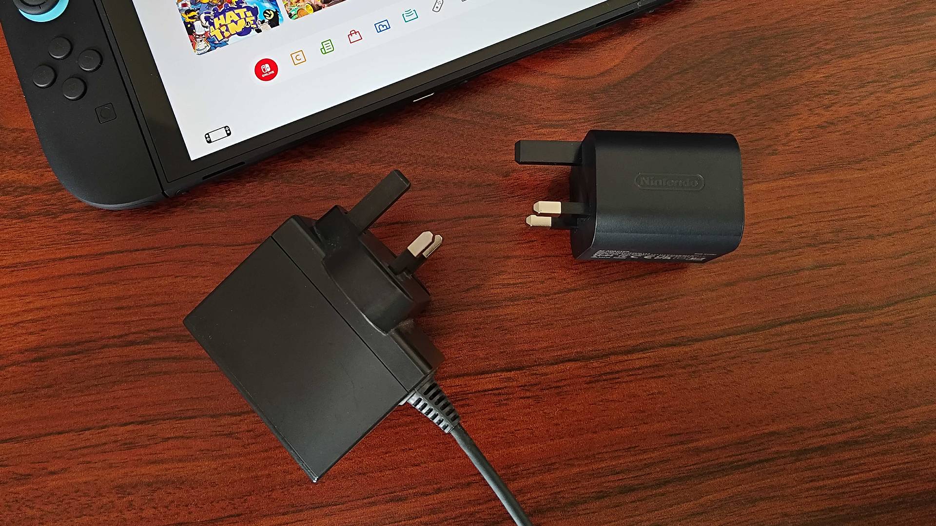 Switch 2 power adapter next to original Switch charger on desk.