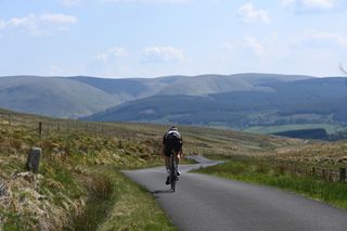 Image shows a person cycling in Scotland