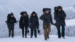 Abby (Kaitlyn Dever, second from right) and fellow soldiers from the Washington Liberation Front march fully-armed through a cold, snowy landscape in The Last of Us Season 2.