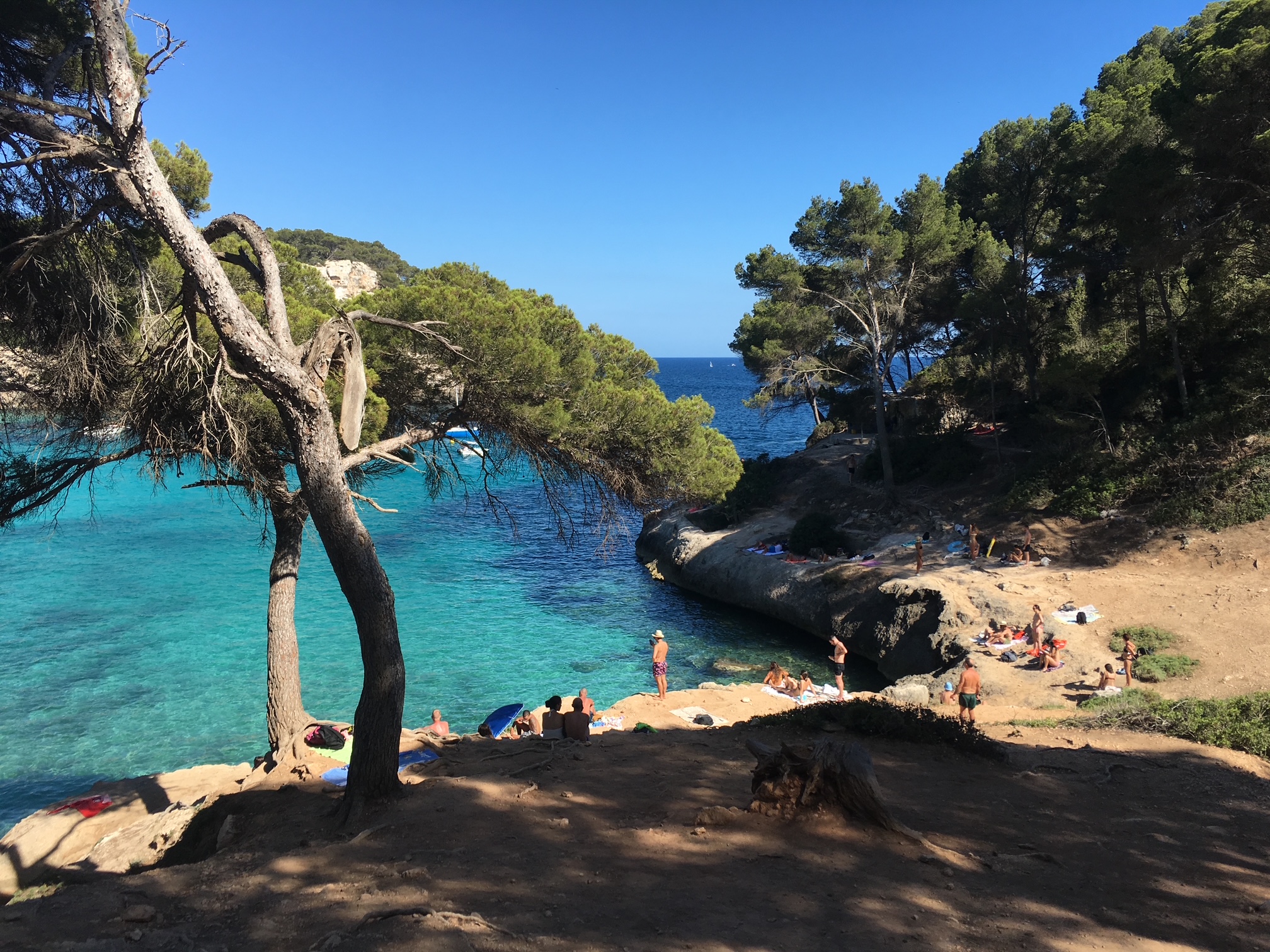 Scene of swimmers at a beach on the island of Menorca, Spain.