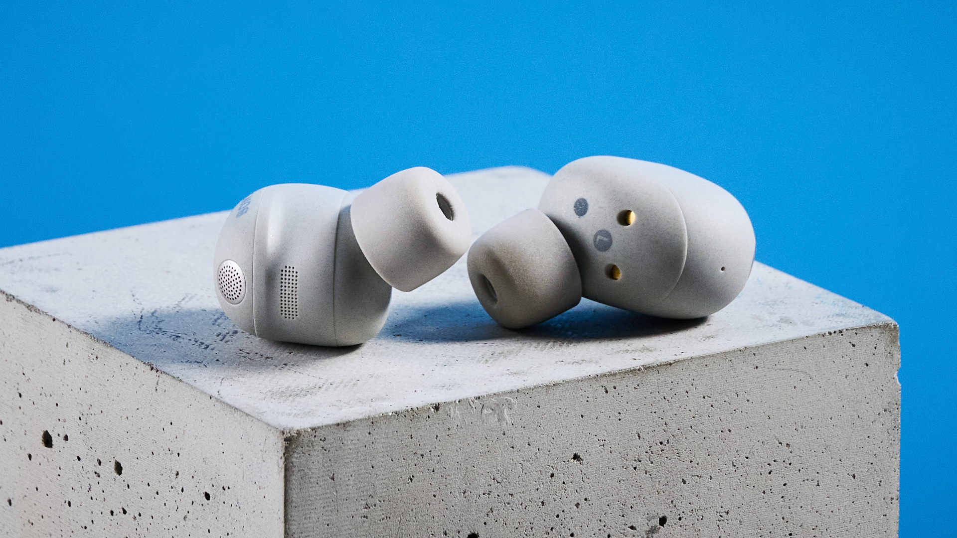 Sony WF-1000XM6 earbuds photographed in front of a blue background