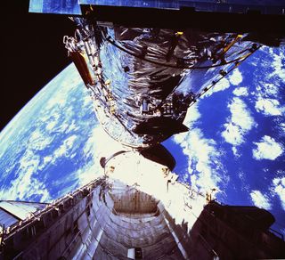 In this photograph, the Hubble Space Telescope (HST) is clearing the cargo bay during its deployment on April 25, 1990. The photograph was taken by the IMAX Cargo Bay Camera (ICBC) mounted in a container on the port side of the Space Shuttle orbiter Disco