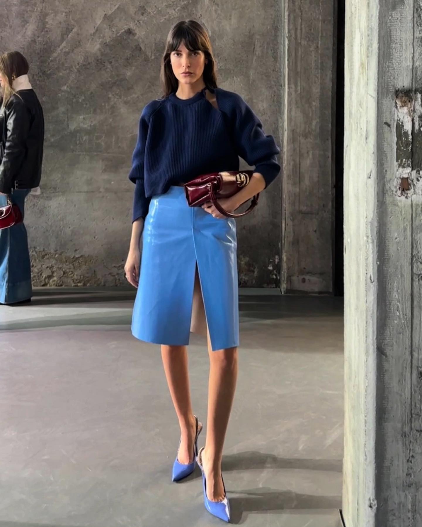 Leia Sfez wearing a navy sweater with a periwinkle blue skirt and shoes from Gucci.