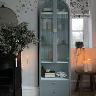 blue painted wooden cabinet with glass door and drawers