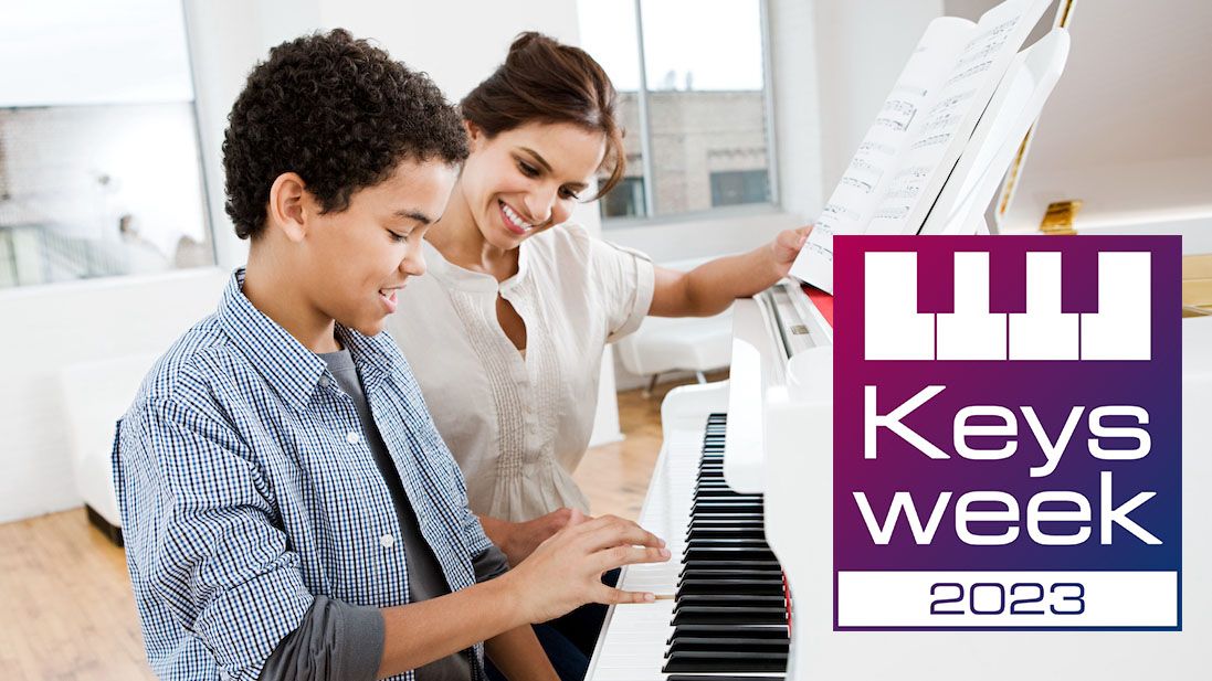 Woman and boy sit at a white piano