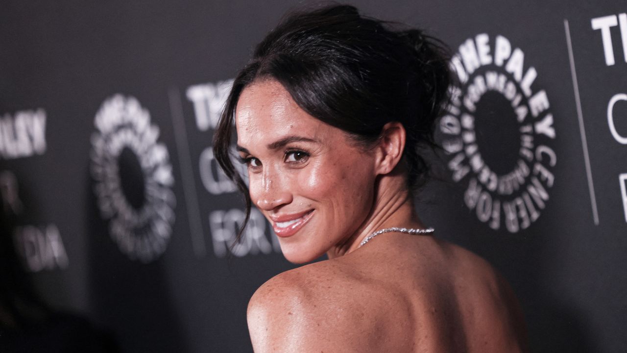 Meghan Markle on a red carpet wearing her favorite liquid highlighter drops