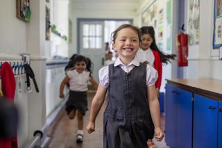 School children running down school hallway