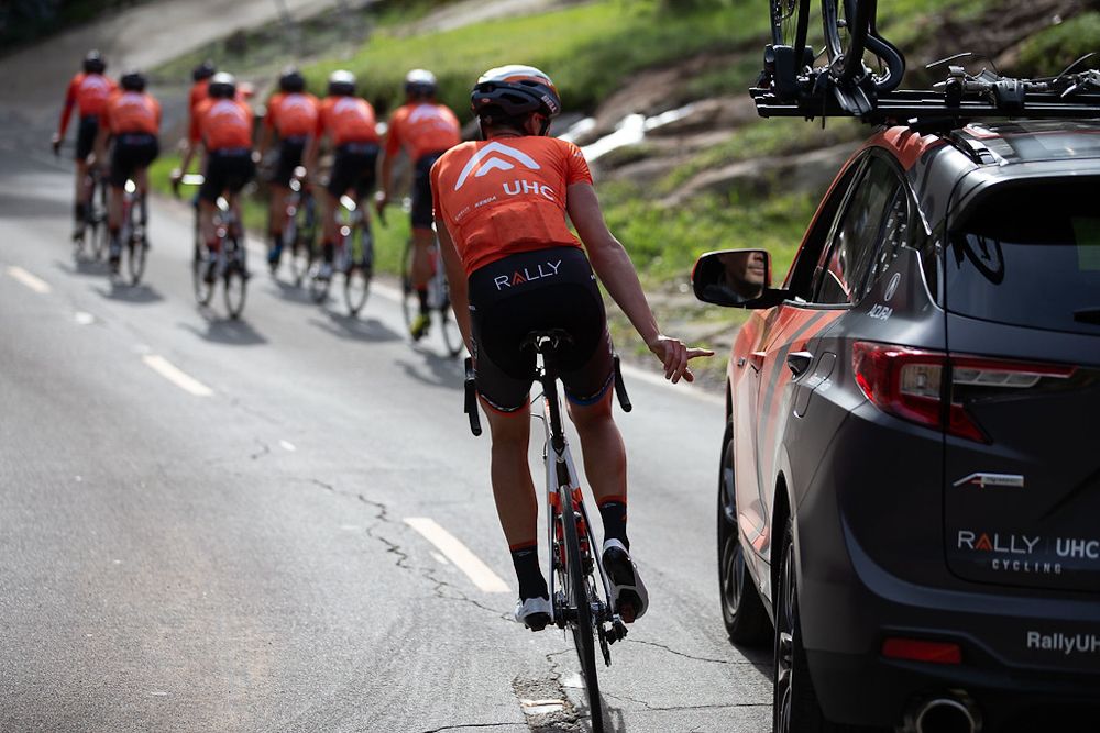 A rally UHC rider goes back to the team car for a snack
