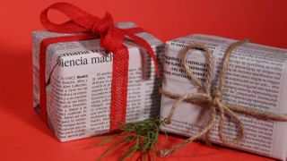 Presents wrapped in newspaper and secured with red ribbon and string