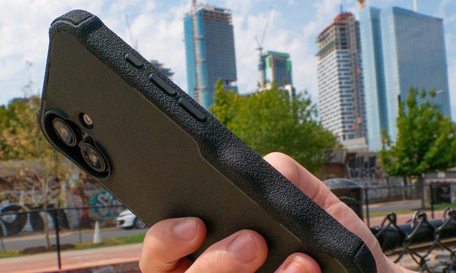 Best iPhone 16 cases smartish Gripzilla held in a hand in front of a cityscape