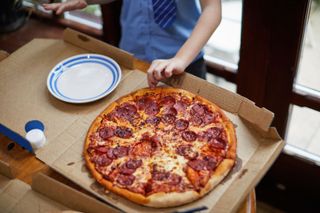 A pepperoni pizza in a takeaway box