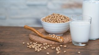 Bowl of soybeans next to glass of milk