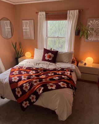 Bright throw over monochromatic bedspread in cozy small space with soft lighting