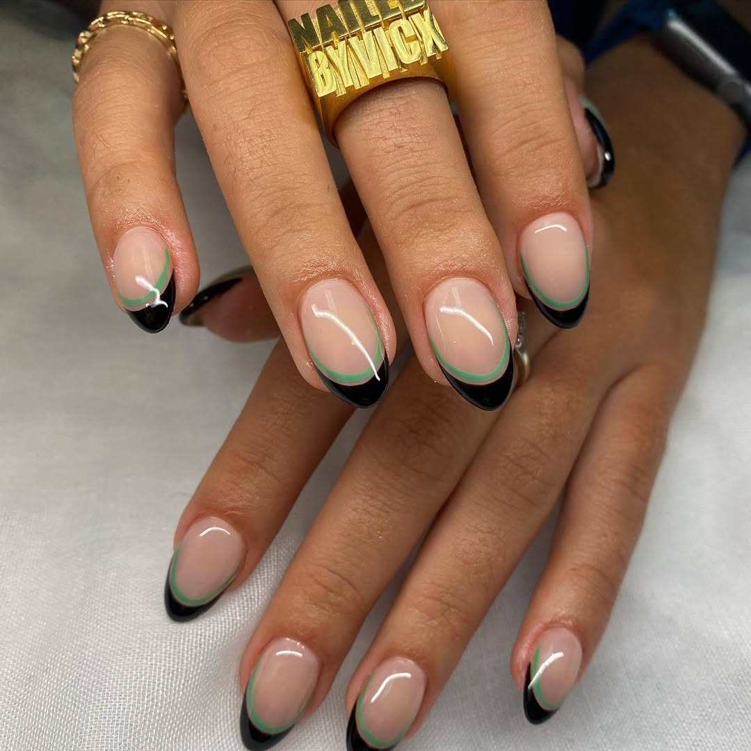 a person wearing a double french manicure with black and green tips